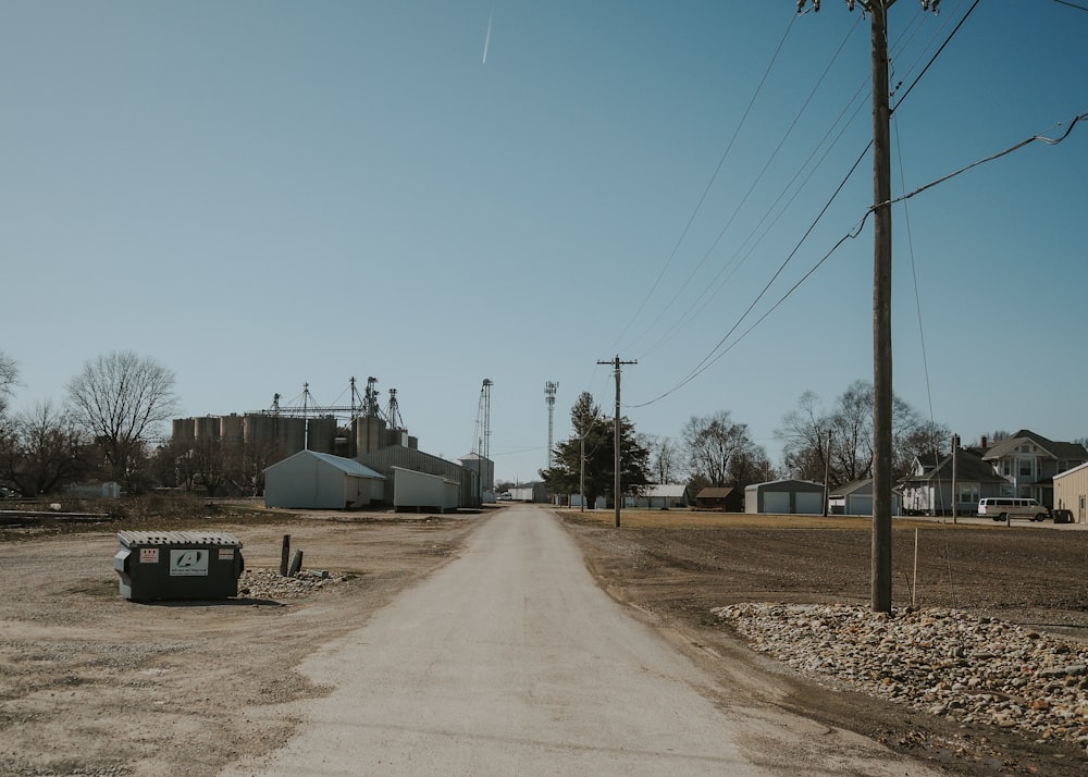 a dirt road in front of a factory