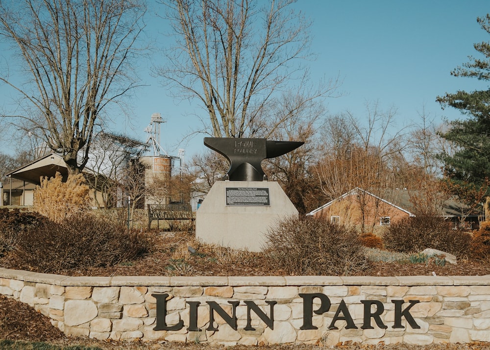 a sign for linn park in front of some trees