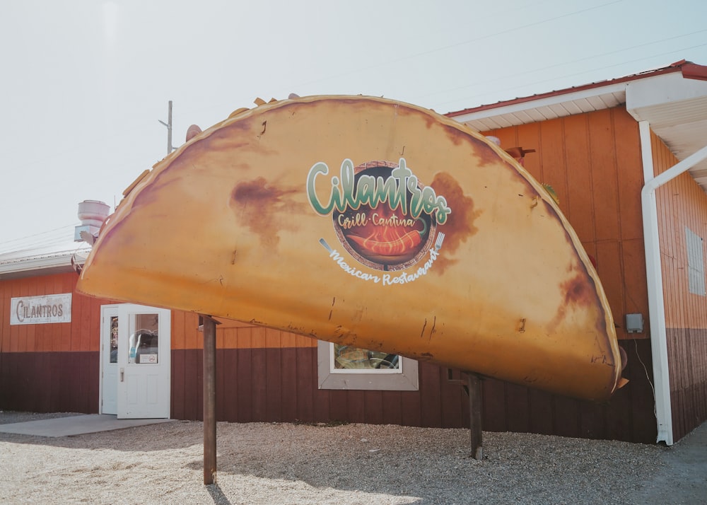 a large yellow surfboard sitting in front of a building