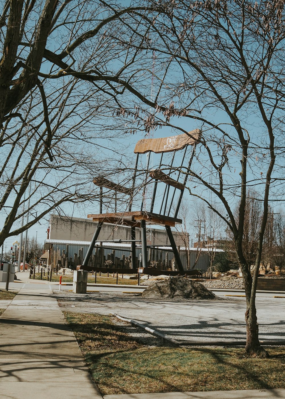 a large metal chair sitting on top of a tree