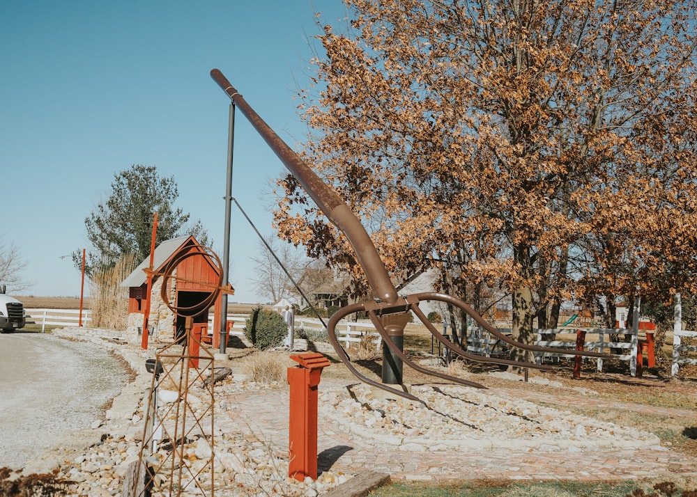 a rusted metal sculpture in the middle of a dirt road