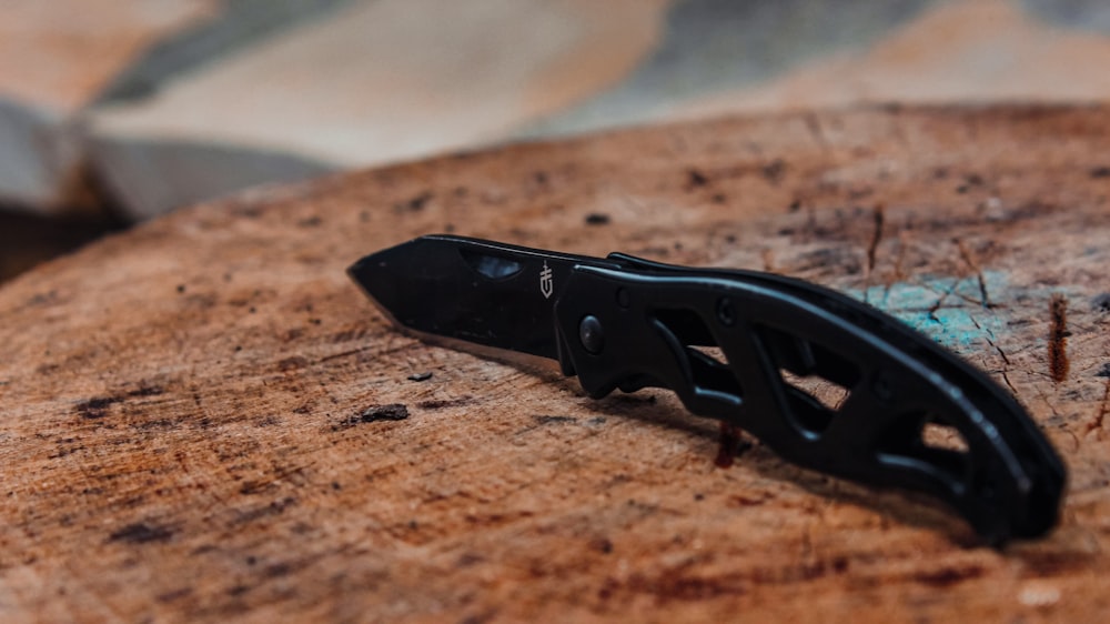 a small black object sitting on top of a piece of wood