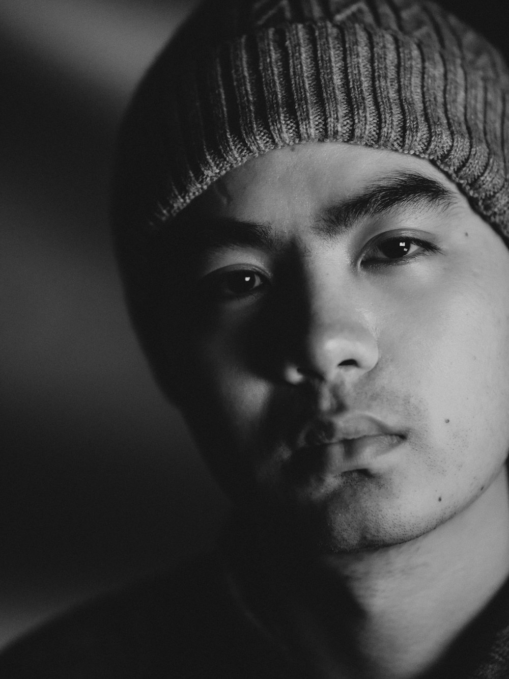 a black and white photo of a man wearing a hat