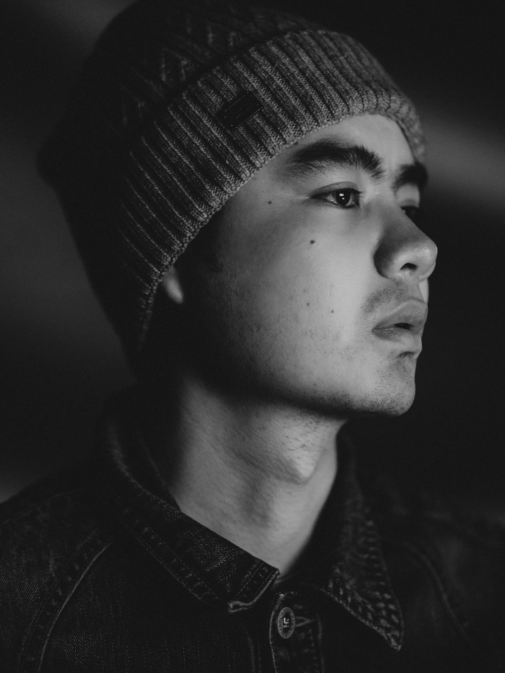 a black and white photo of a man wearing a beanie