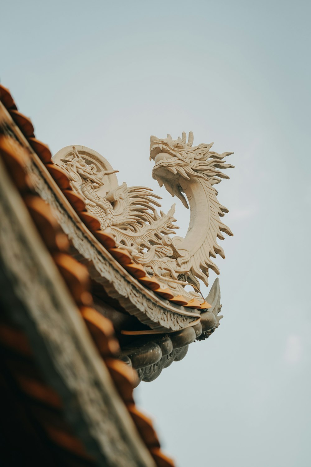 a close up of a roof with a dragon decoration on it