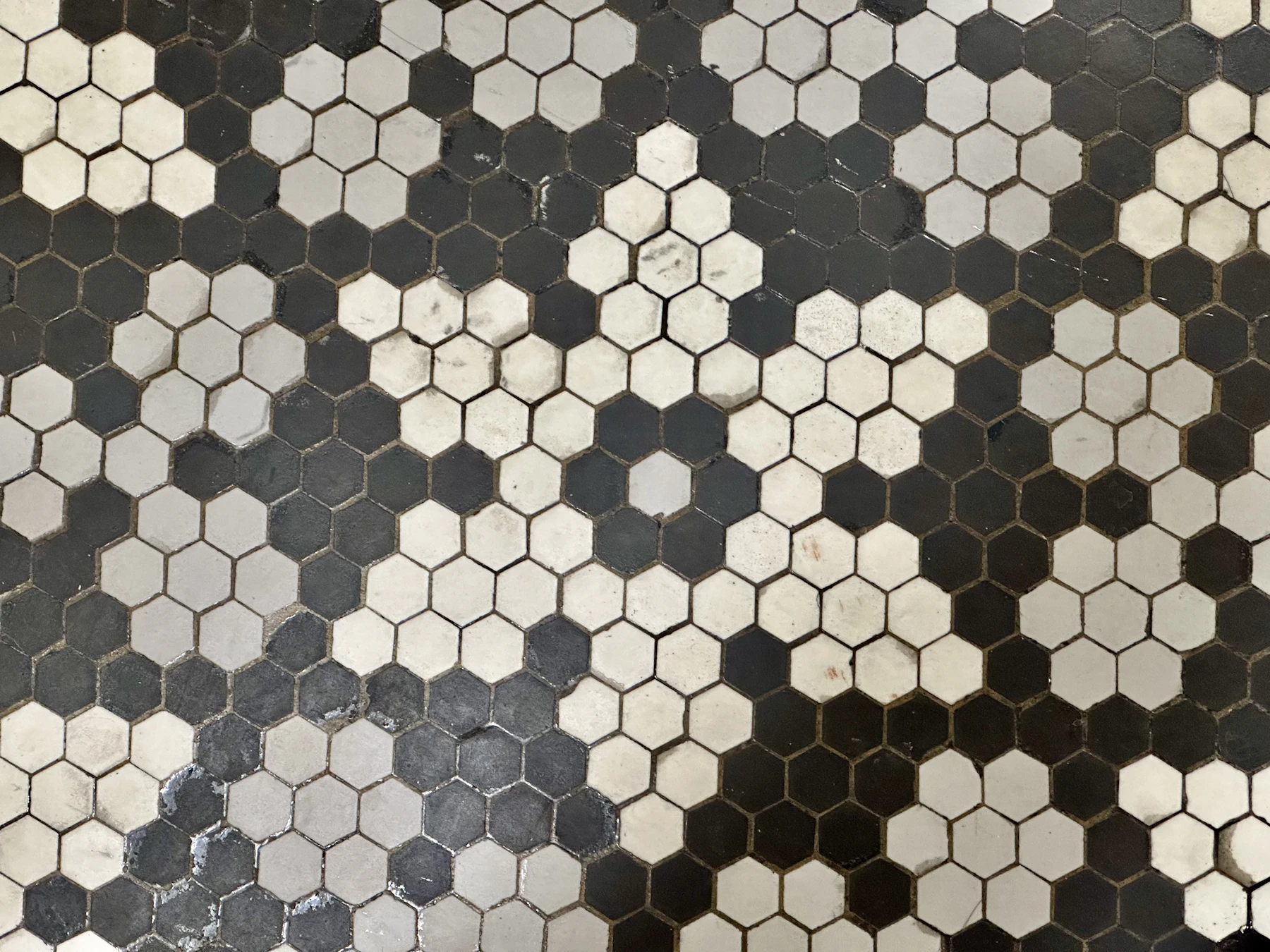 A floor of small black, white and gray hexagonal mosaic tiles with narrow grout joints