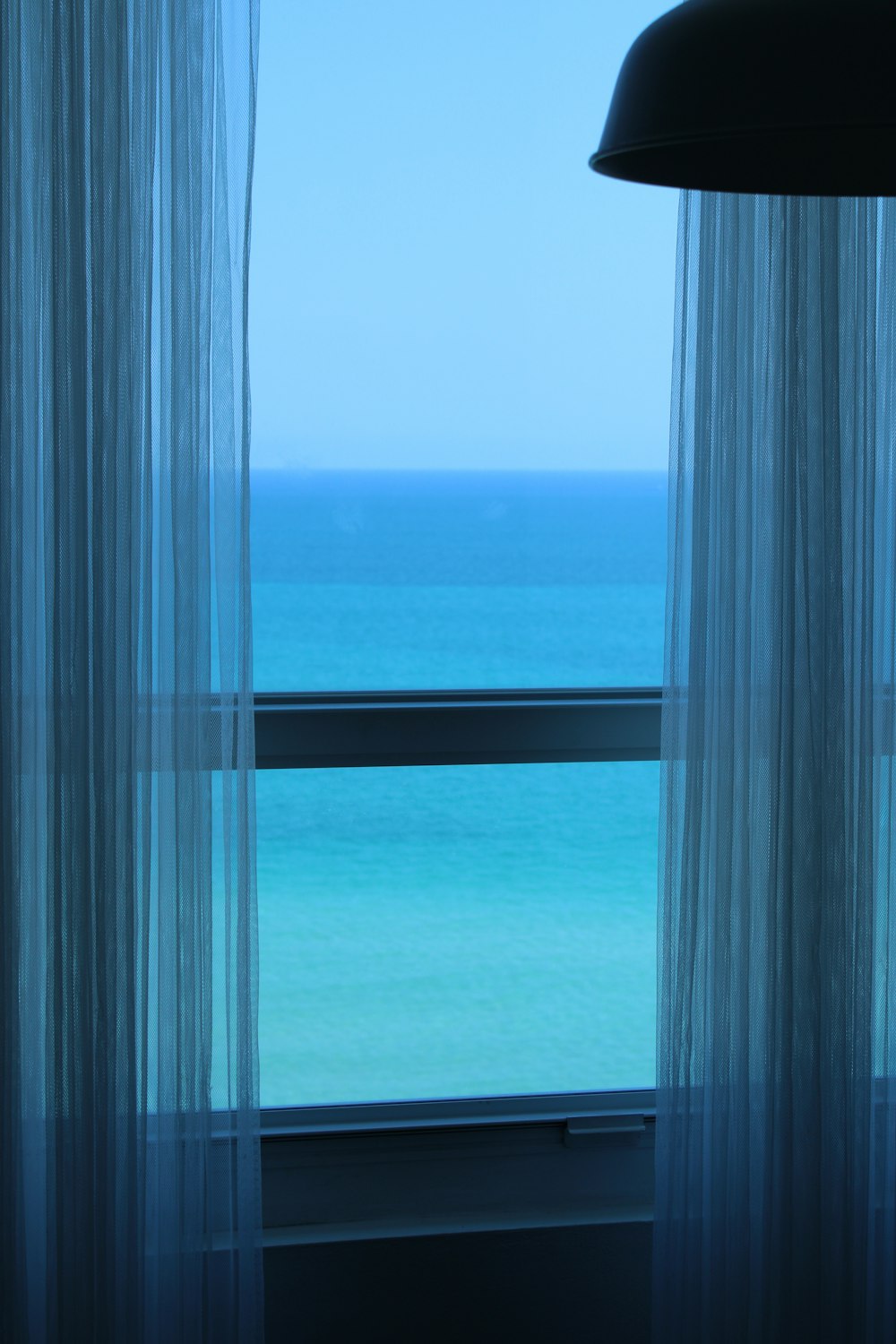 a view of the ocean from a hotel room window