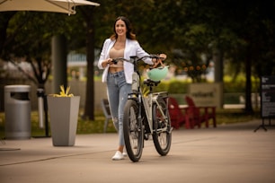 a woman standing next to a bike on a sidewalk