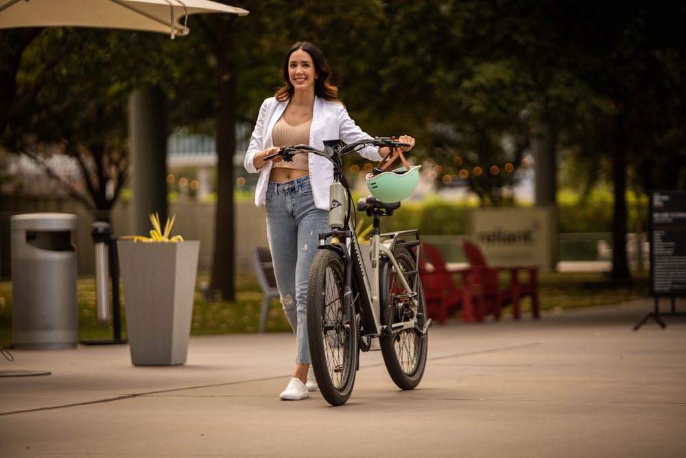 a woman standing next to a bike on a sidewalk