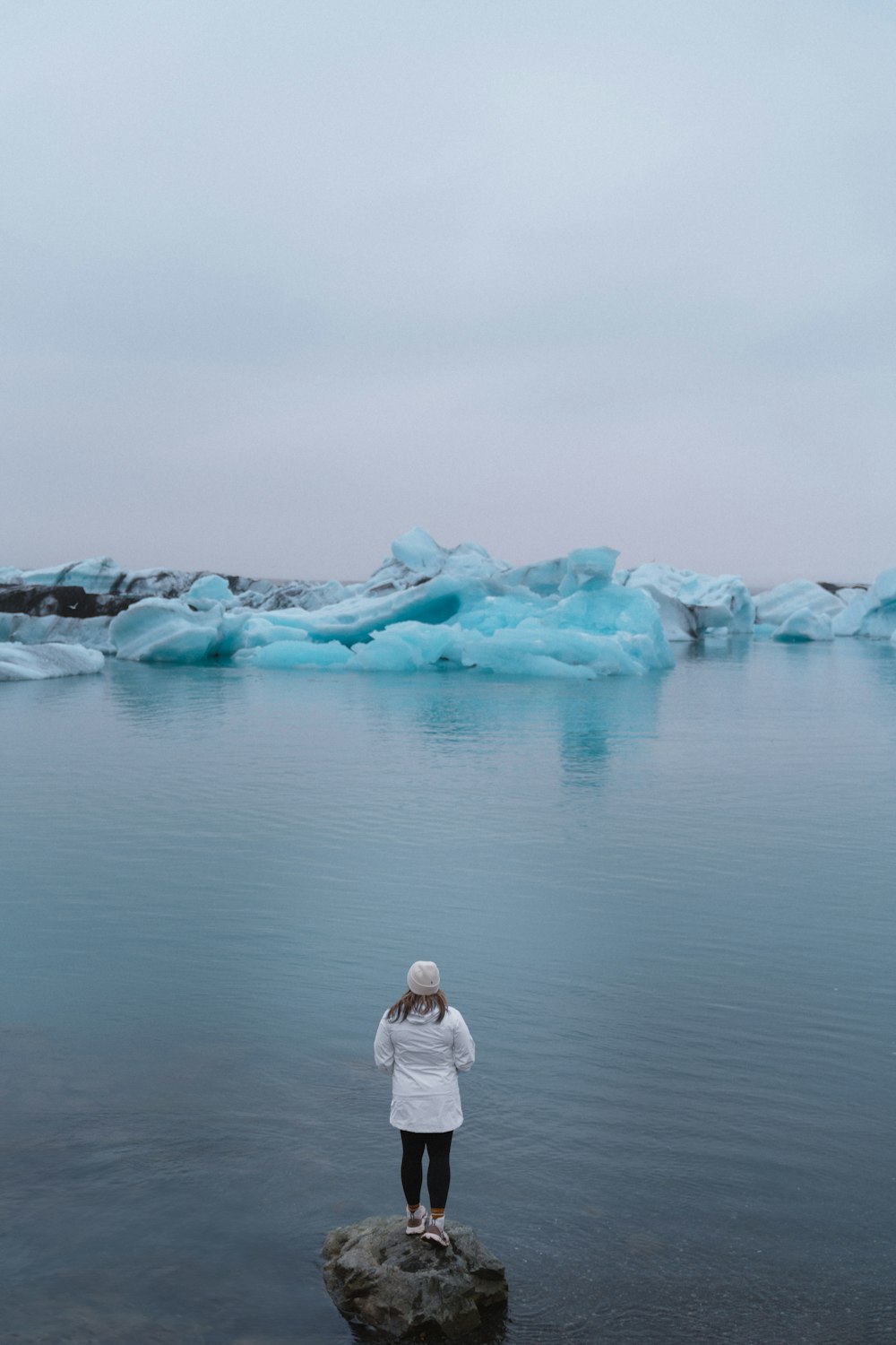 a person standing on a rock in the water