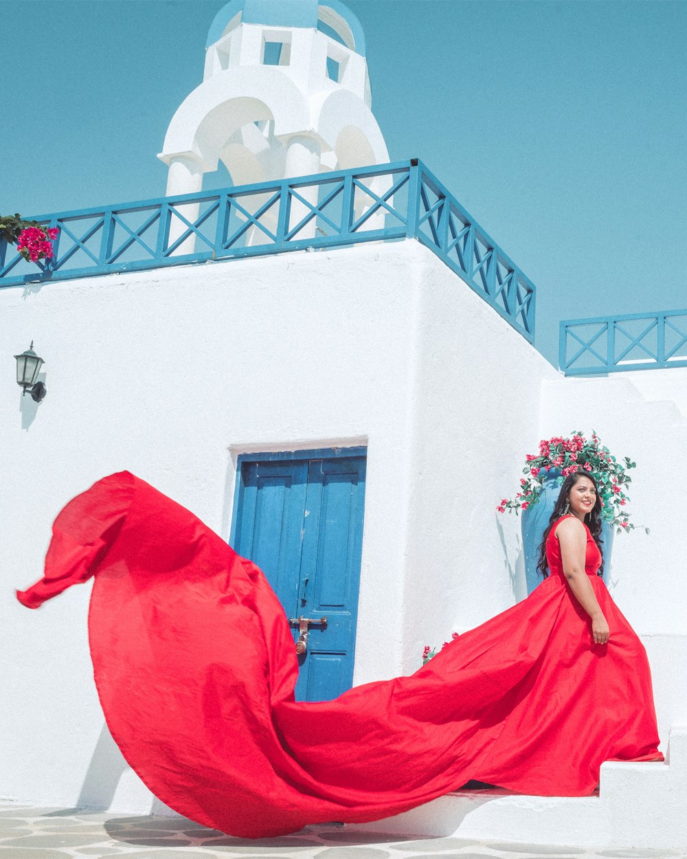 a woman in a red dress standing in front of a white building