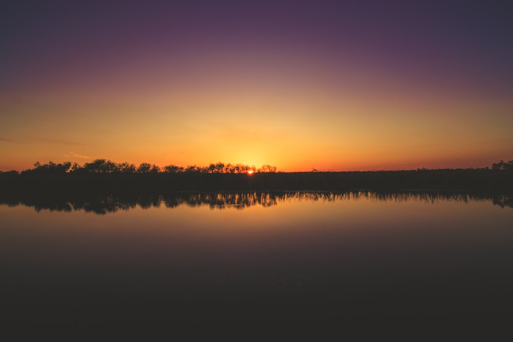 the sun is setting over a body of water