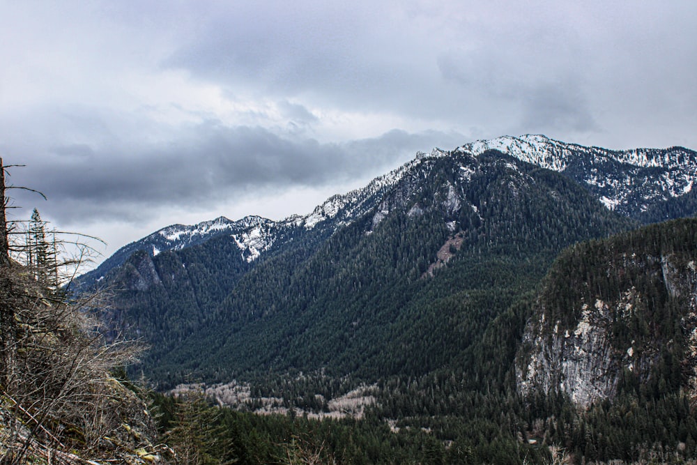 a view of a mountain range with trees and mountains in the background