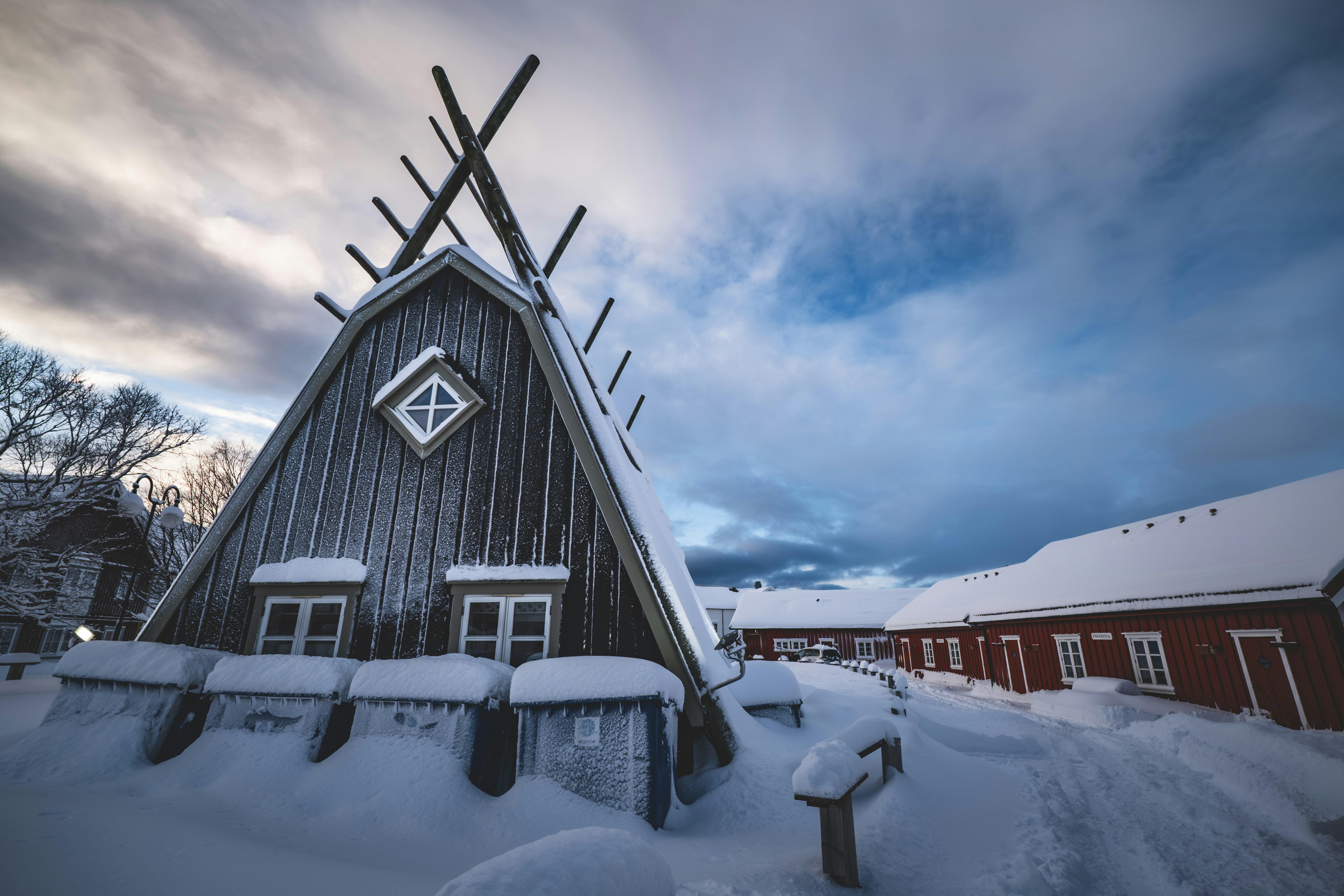a wooden building with a weather vane on top of it