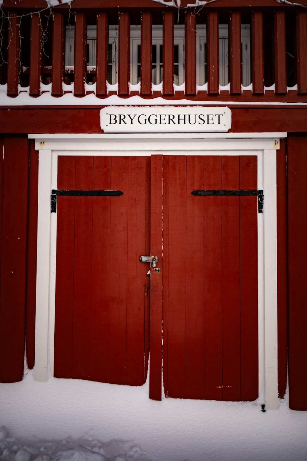 a red building with two doors in the snow
