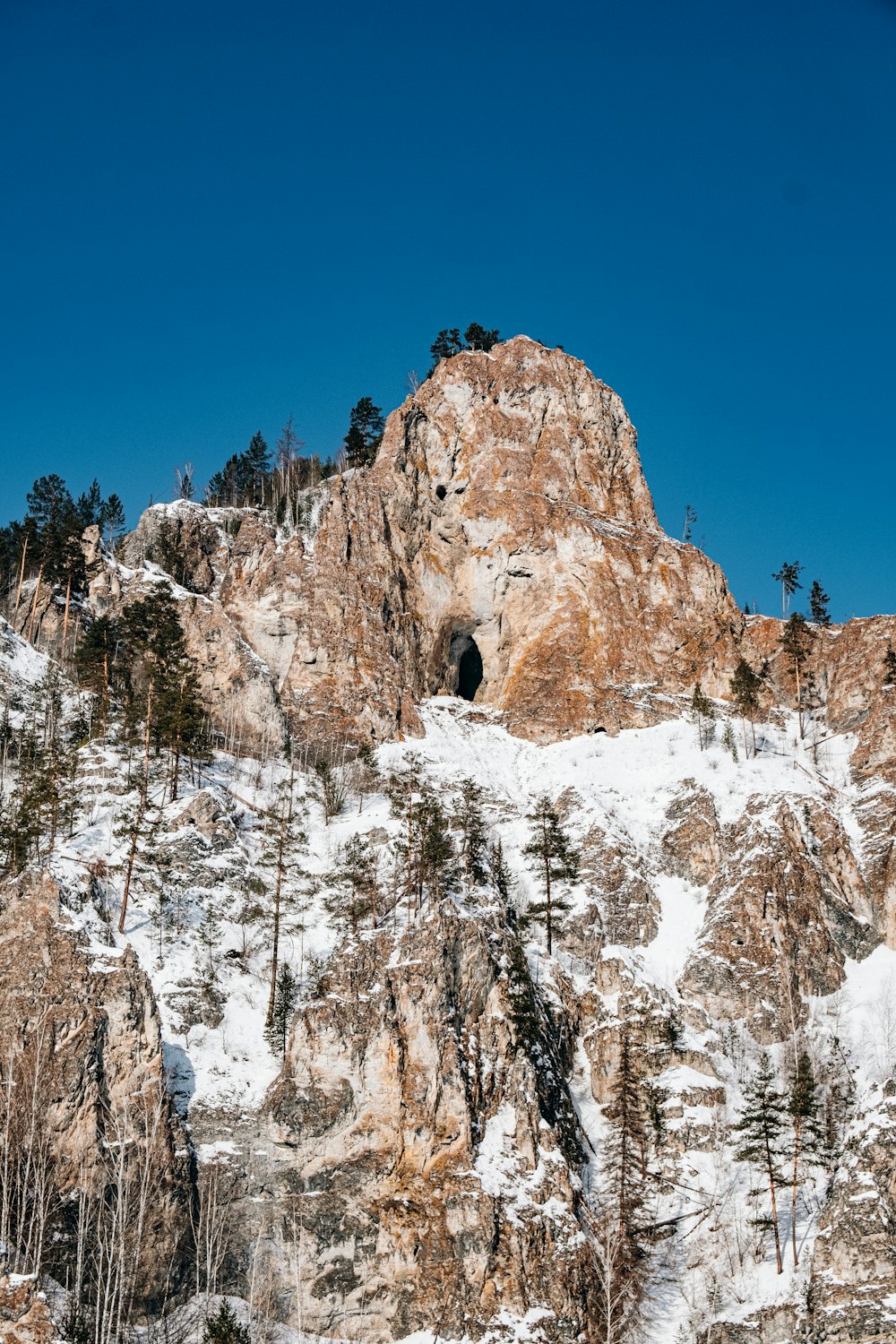 a snow covered mountain with a cave in the middle