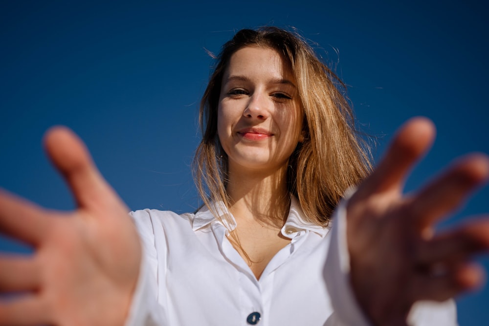 a woman in a white shirt holding out her hands