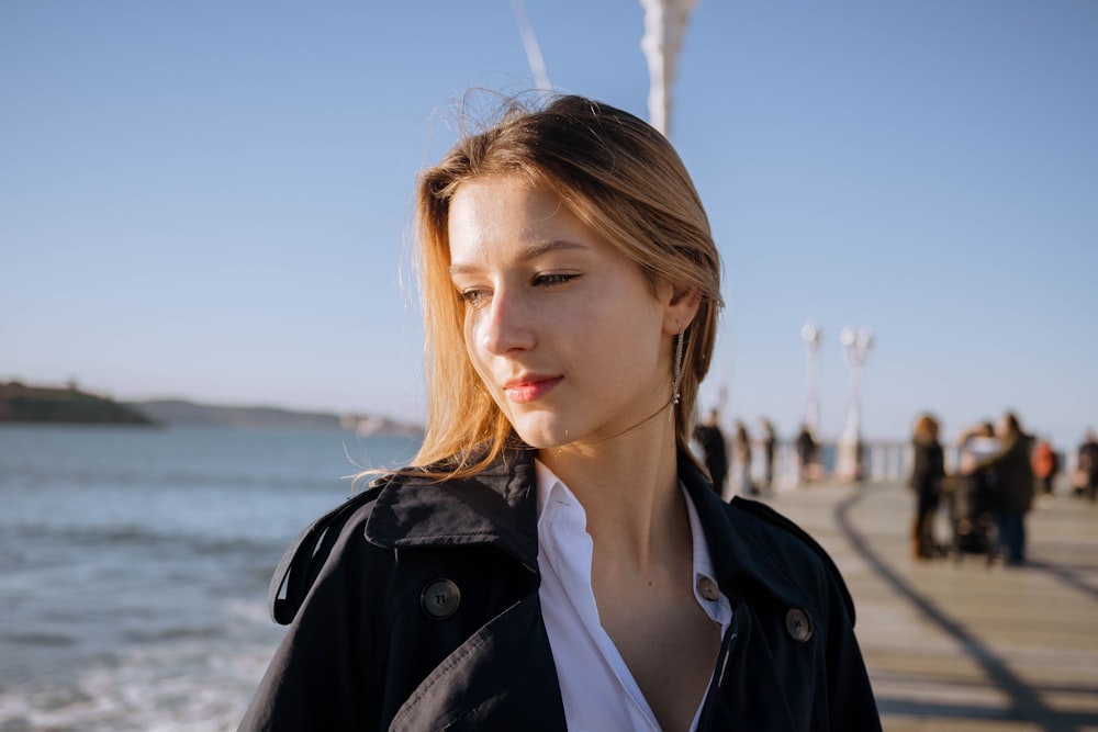 a woman standing next to a body of water