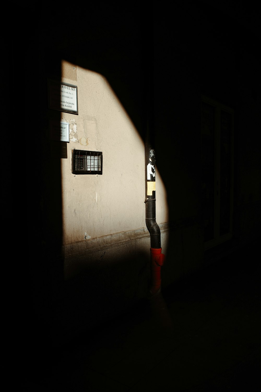 a parking meter sitting next to a building in the dark