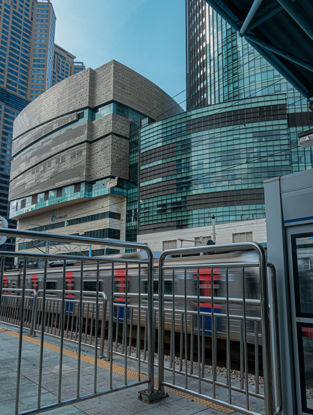 a train traveling through a train station next to tall buildings