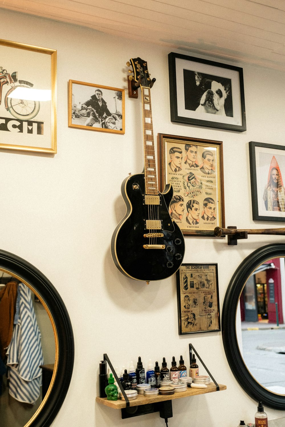 a guitar hanging on a wall next to a mirror