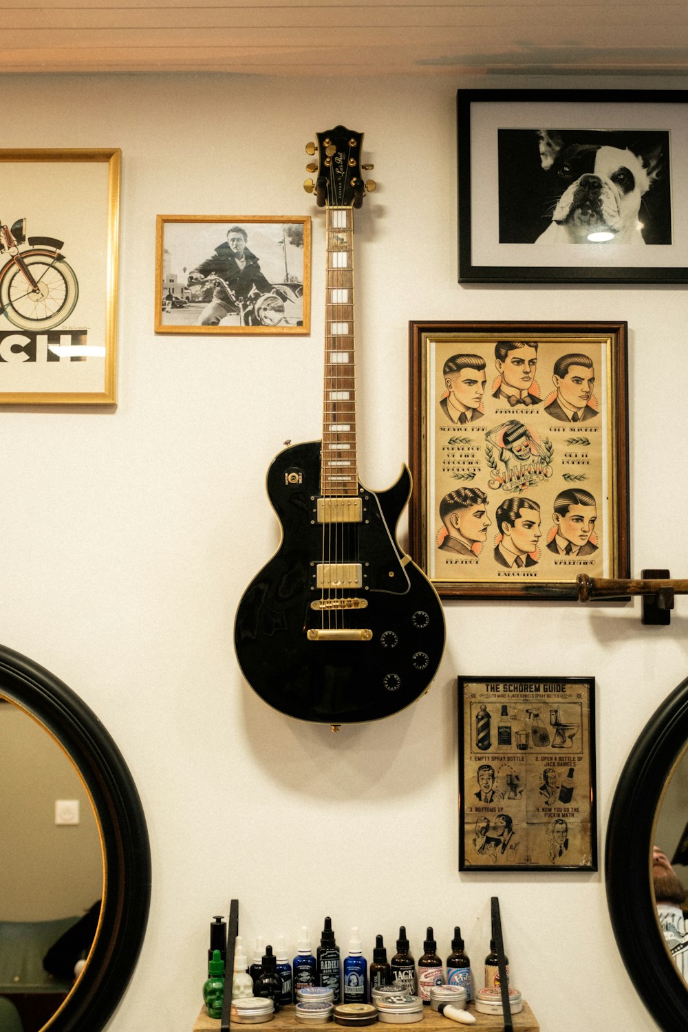 a guitar hanging on a wall next to a mirror