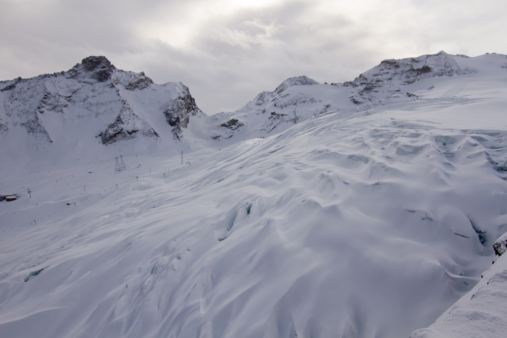 a snow covered mountain with a ski lift in the distance