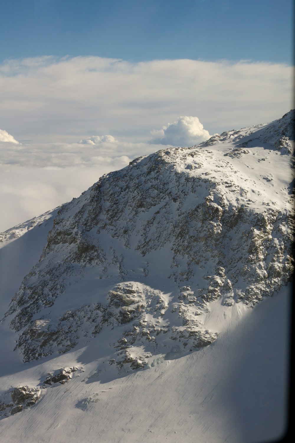 a mountain covered in snow under a blue sky