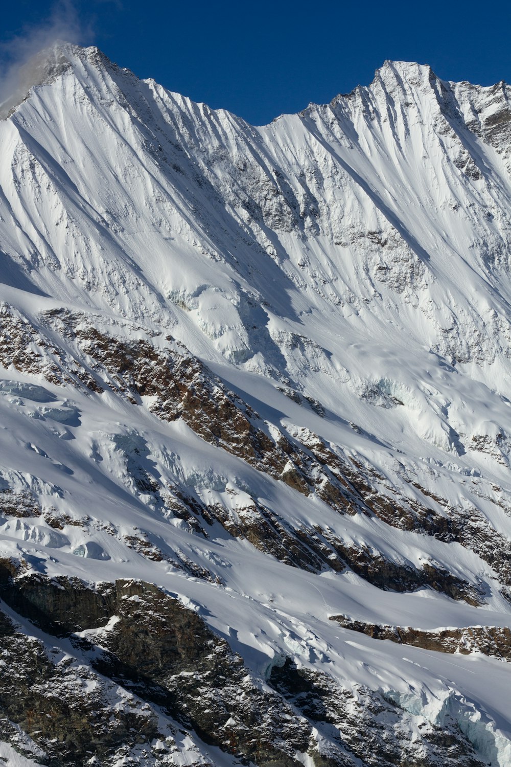 a snow covered mountain with a blue sky in the background