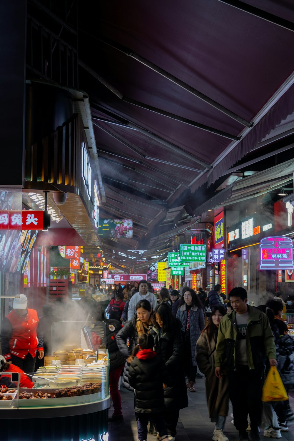 a group of people standing around a food stand