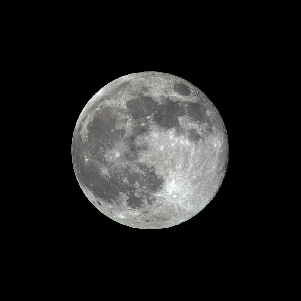 a full moon is seen in the dark sky