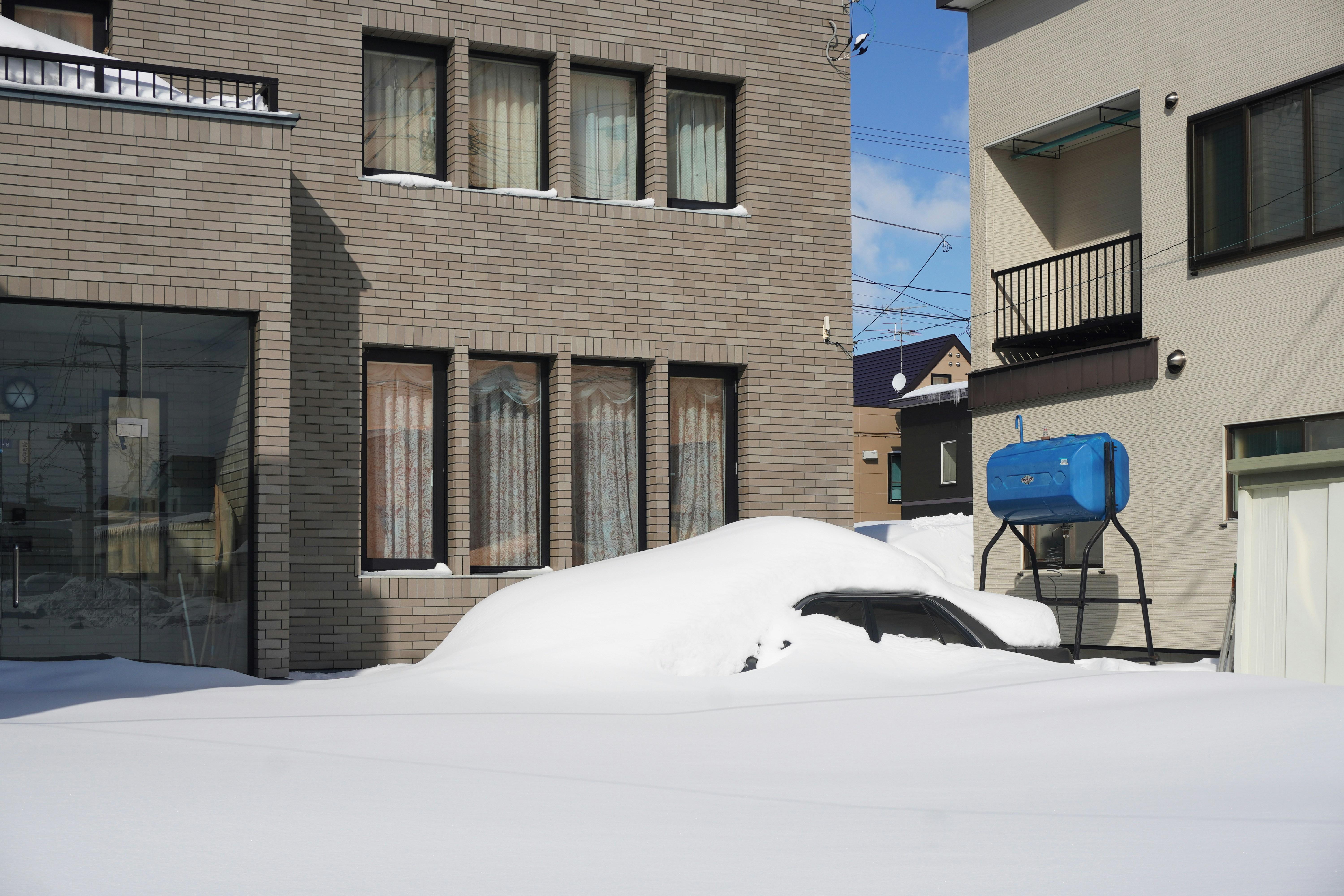 Car stuck in deep snow with exhaust pipe covered, warning for carbon monoxide