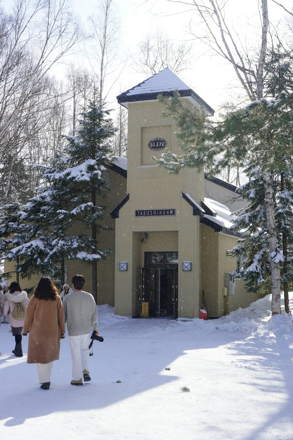 a group of people walking towards a church in the snow