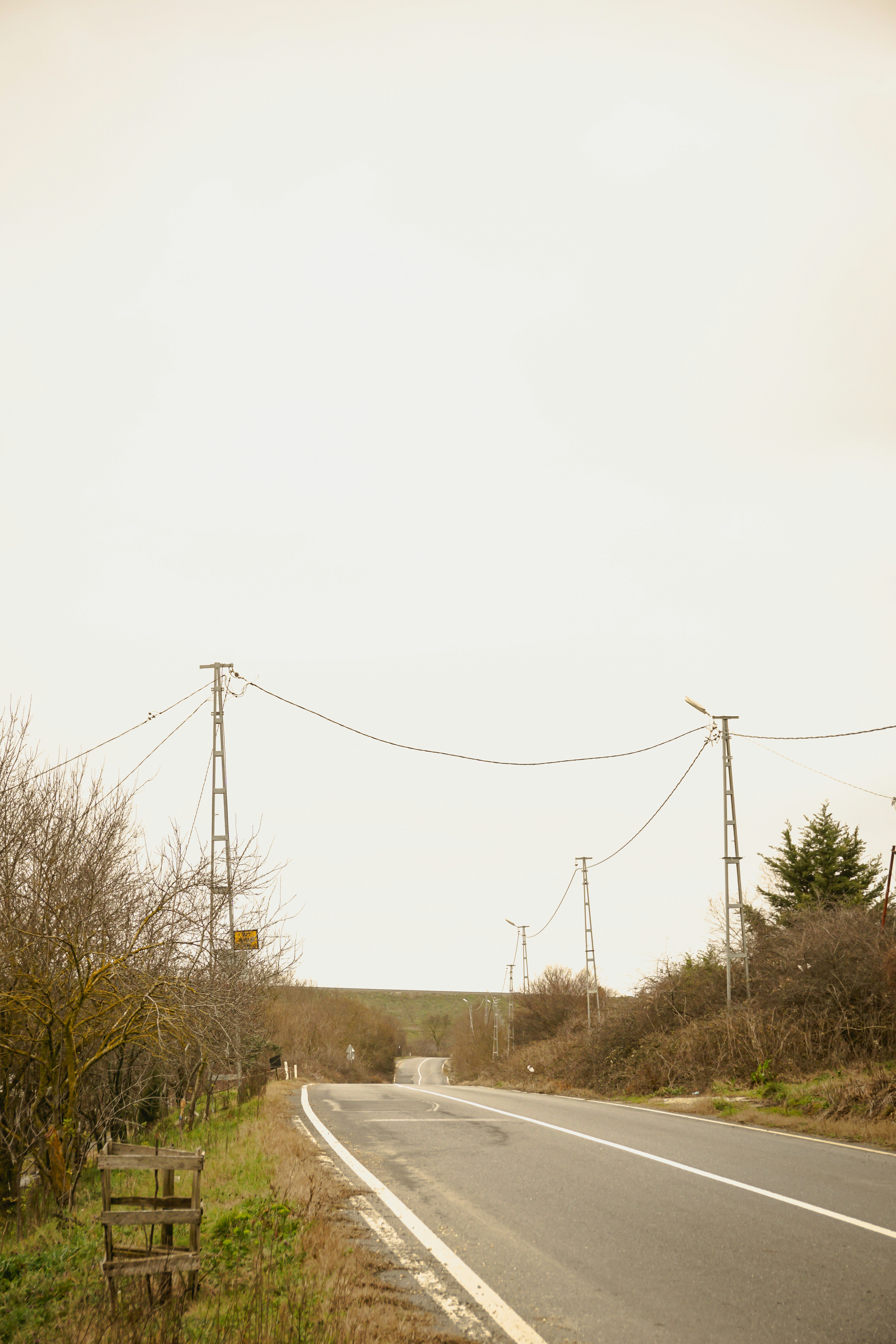 an empty road with power lines above it