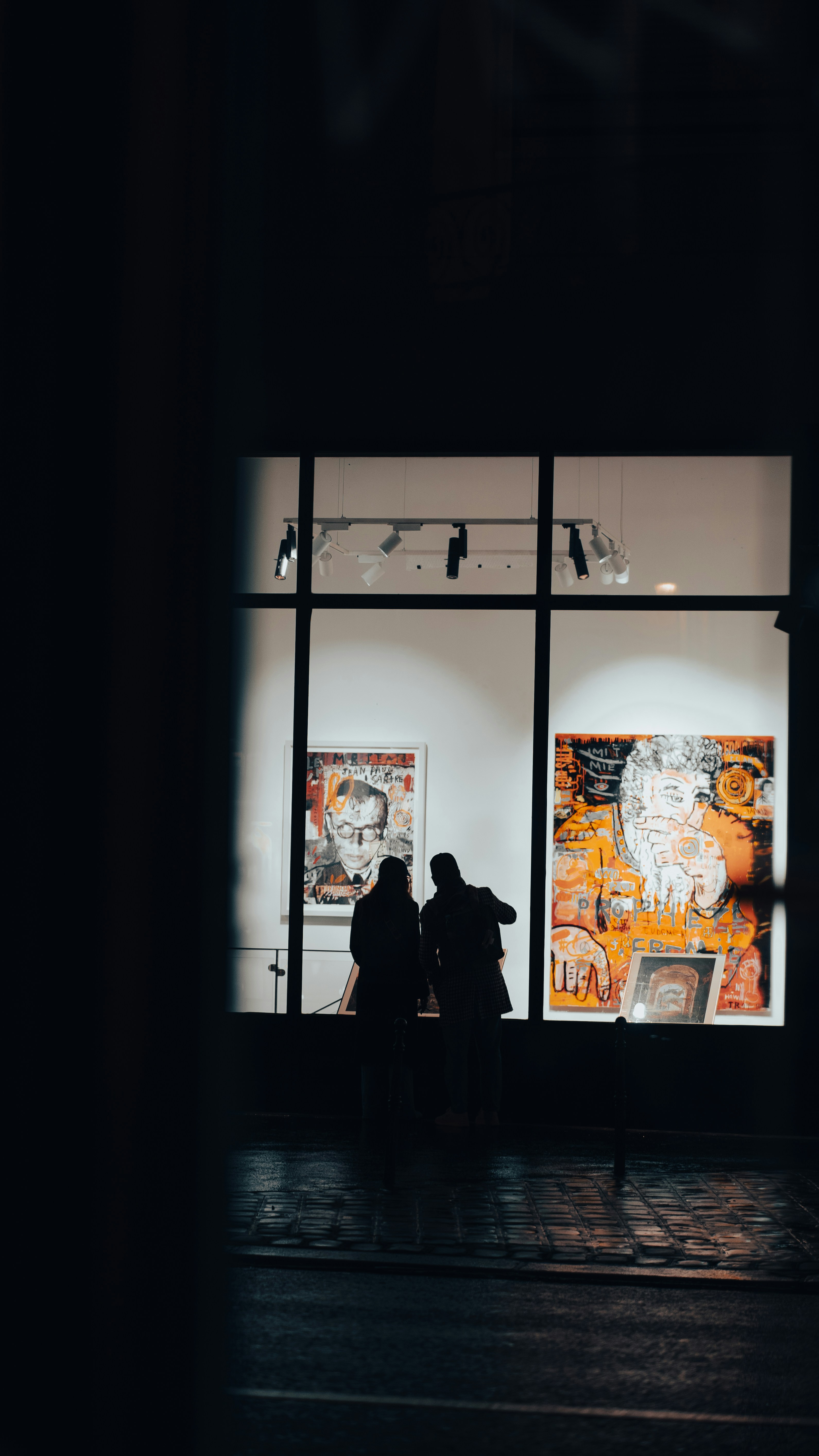 a couple of people standing in front of a window