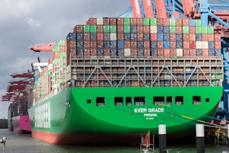 a large green cargo ship docked at a dock