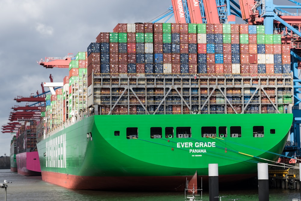a large green cargo ship docked at a dock