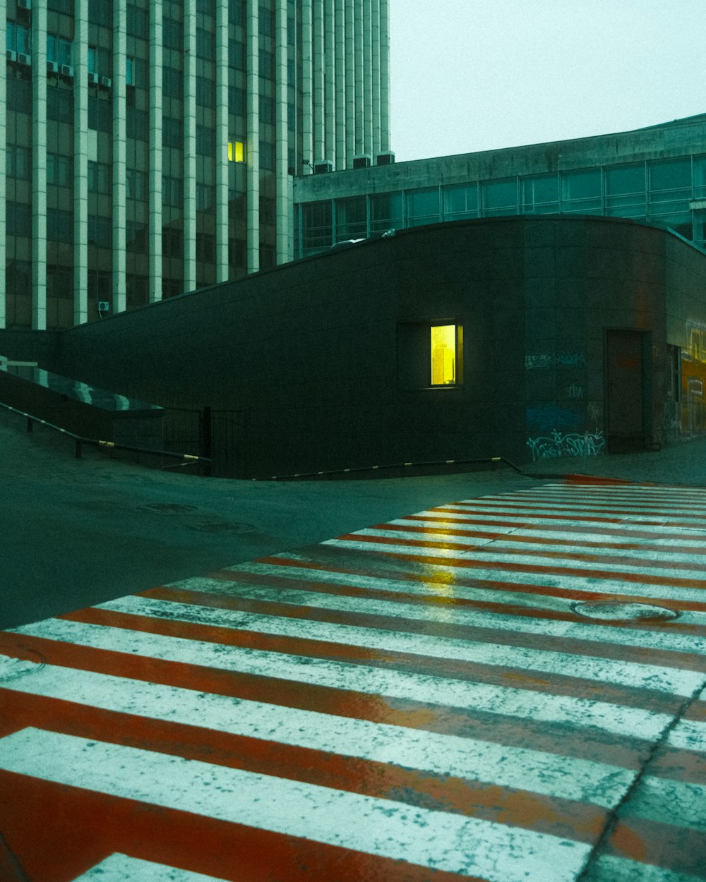 an empty parking lot with a building in the background