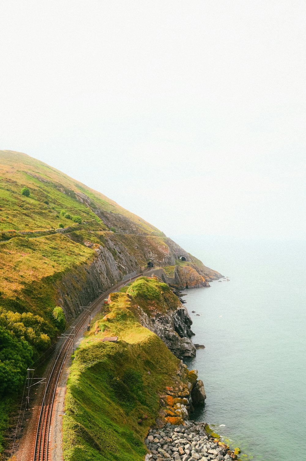 a train on a train track next to the ocean