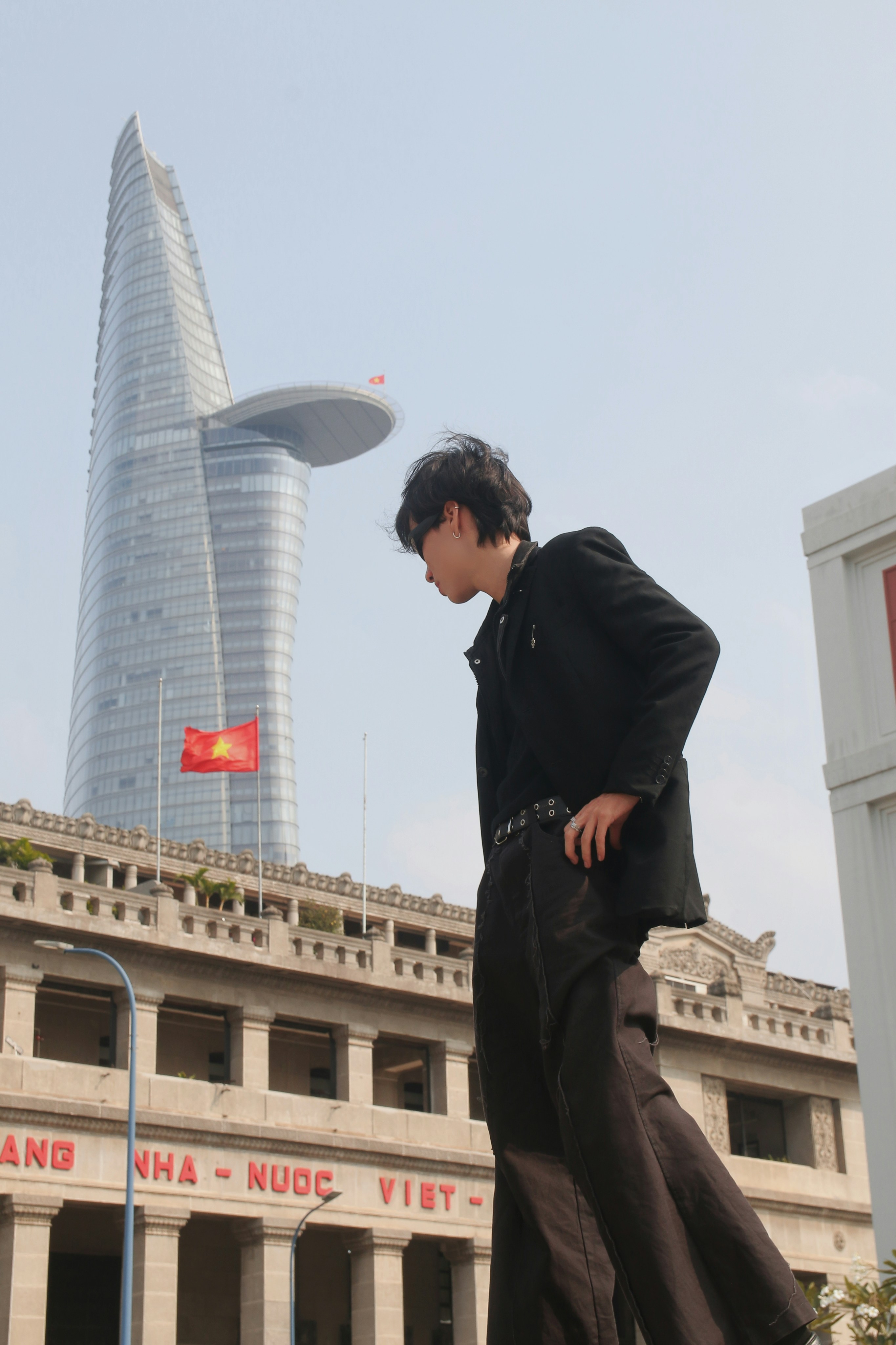 A man walking on a sidewalk in front of a tall building photo – Free ...