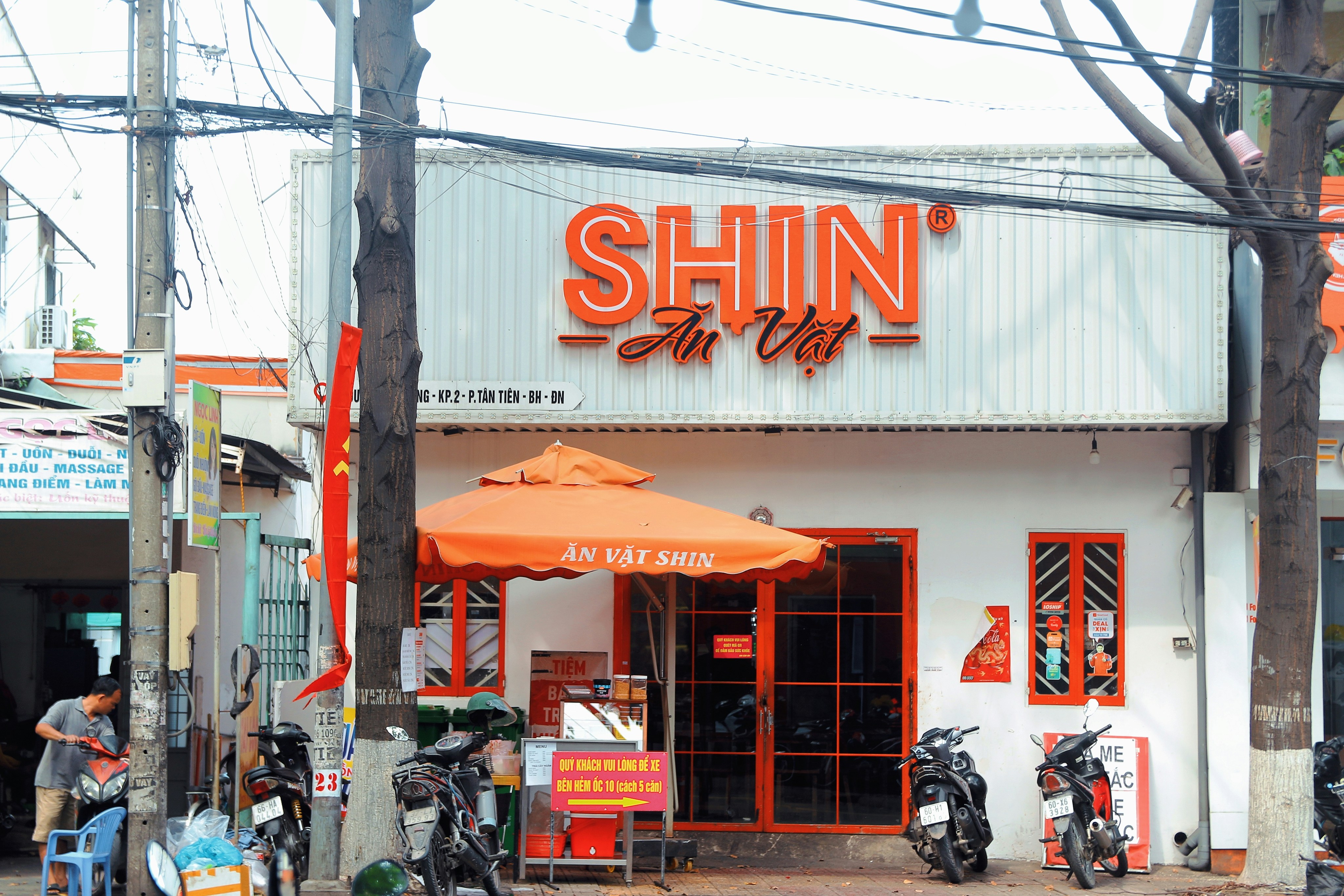 a restaurant with orange awnings and motorcycles parked outside