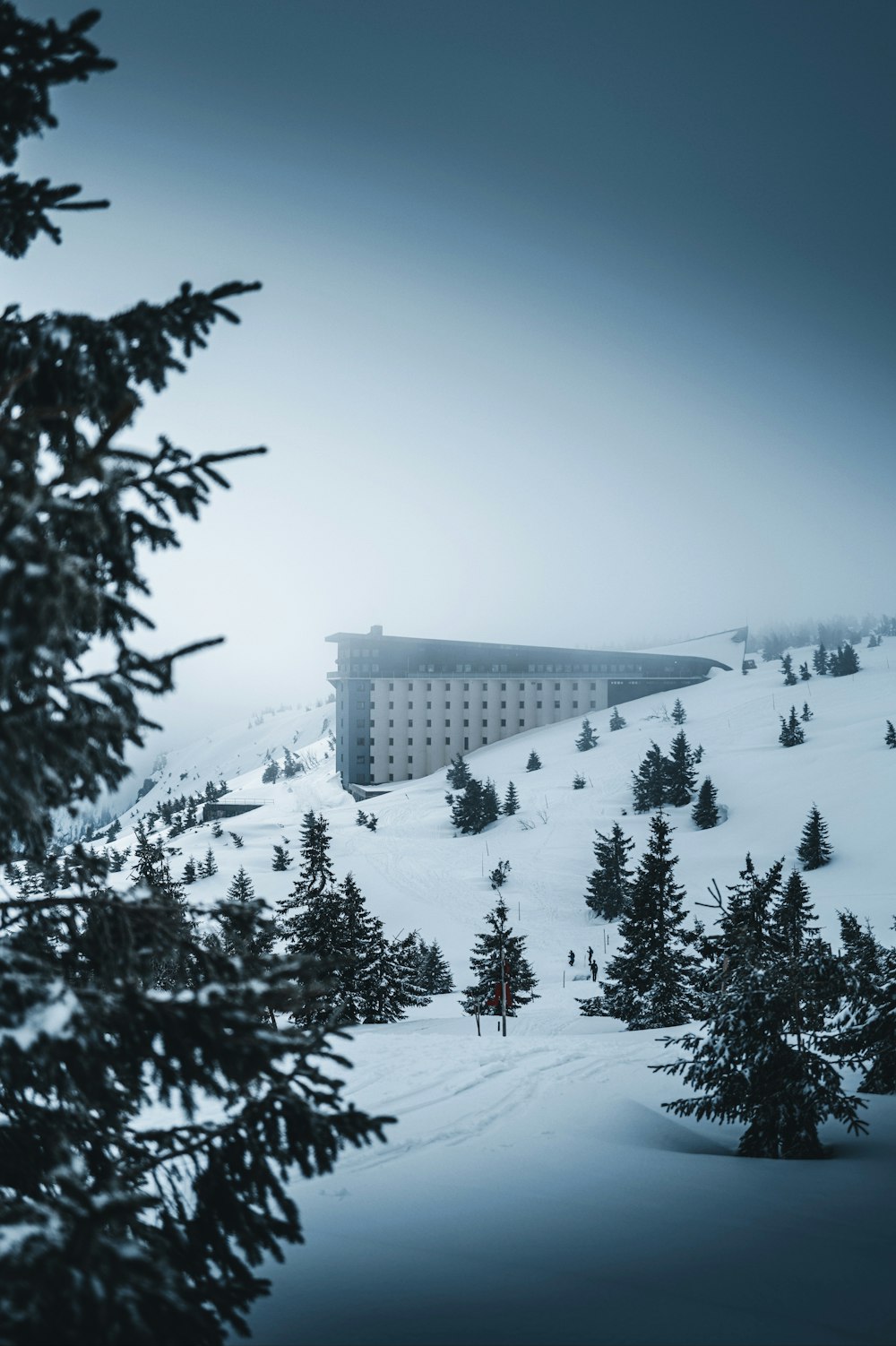 a large building sitting on top of a snow covered slope