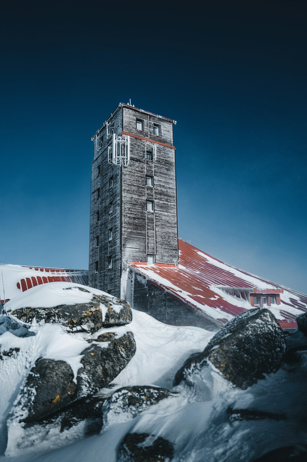 a tall building sitting on top of a snow covered mountain