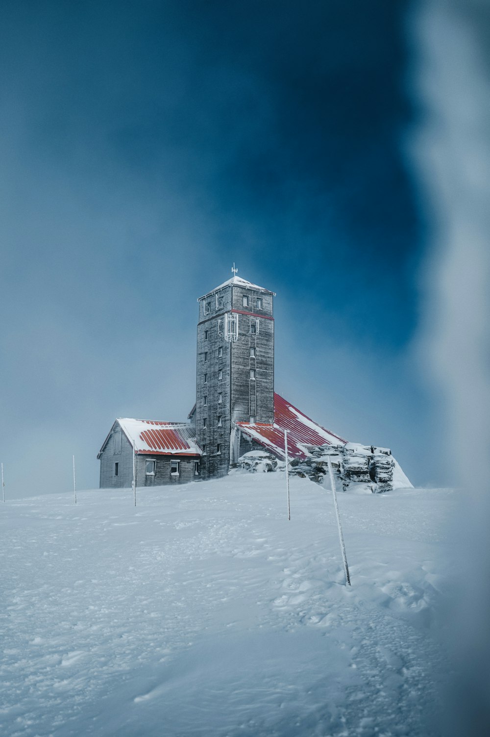 a tall building sitting on top of a snow covered slope