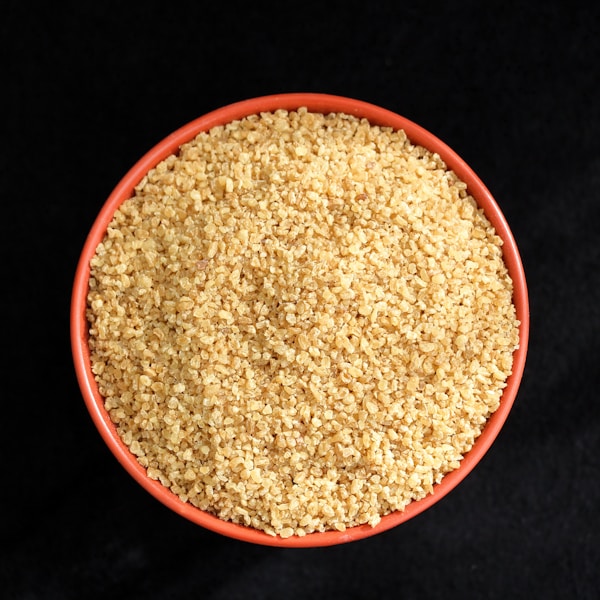 A bowl of sesame seeds on a black background