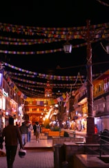 a city street at night with people walking around