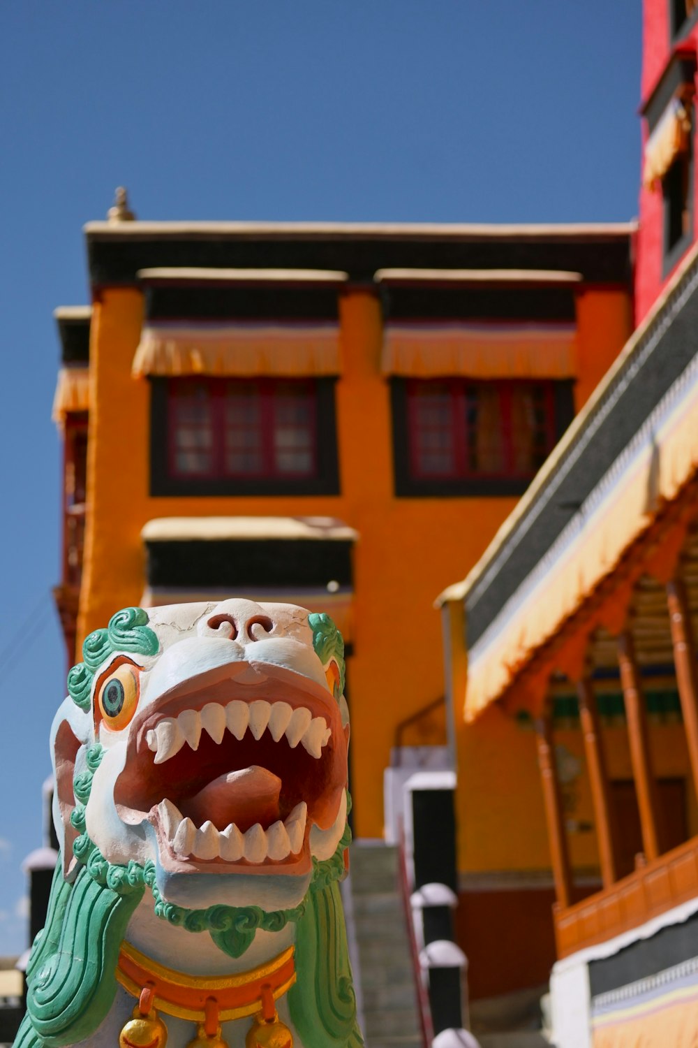 a statue of a dragon with its mouth open in front of a building