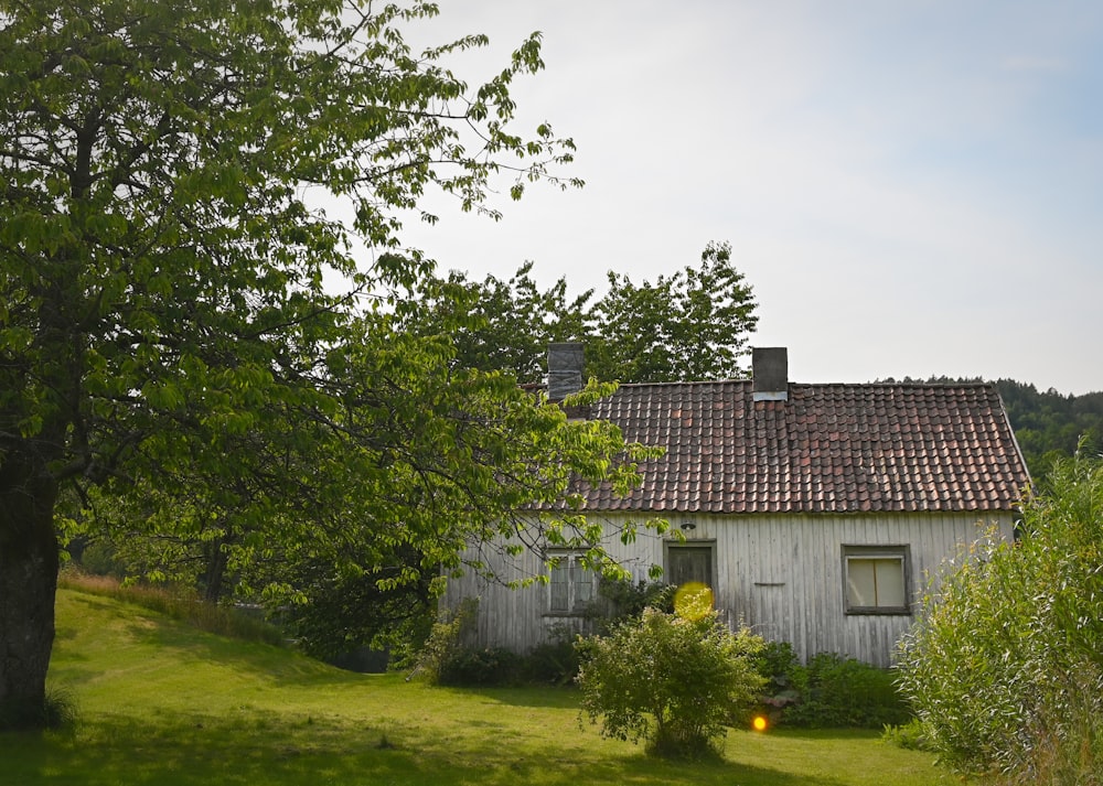 a house with a red tiled roof and a tree in front of it