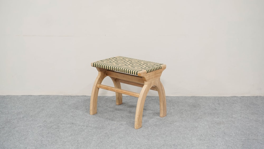 a wooden stool with a patterned seat cushion