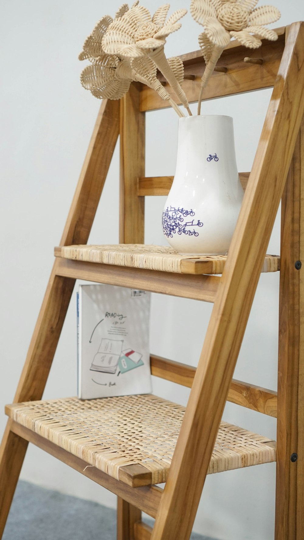 a wooden ladder with a vase on top of it